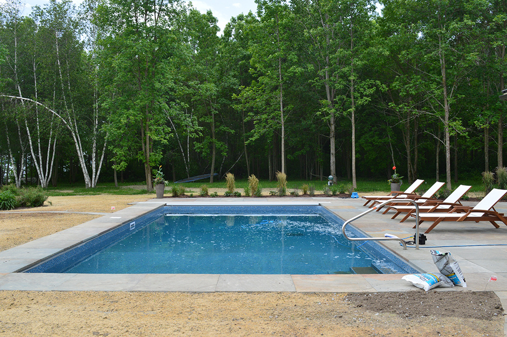inground pool with stone patio